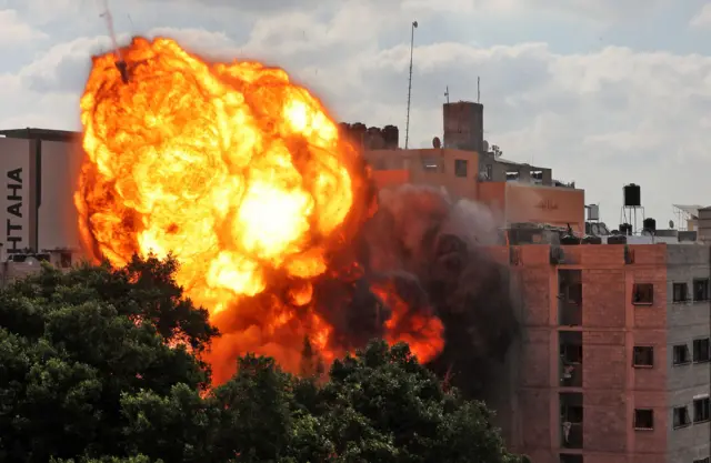 A picture taken on May 13, 2021 shows a ball of fire engulfing the Al-Walid building which was destroyed in an Israeli airstrike on Gaza city early in the morning.