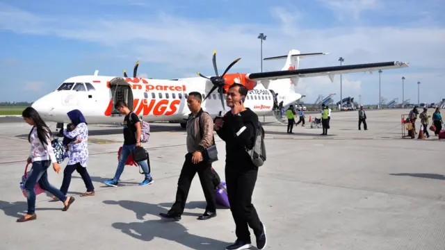 Penumpang pesawat udara berjalan menuju terminal kedatangan saat tiba di Bandara Internasional Kualanamu, Kabupaten Deli Serdang, Sumatera Utara, Senin (14/1/2019).