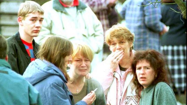 Imagem mostra pessoas chorando após massacre de crianças em escola na Escócia, em 13/03/1996