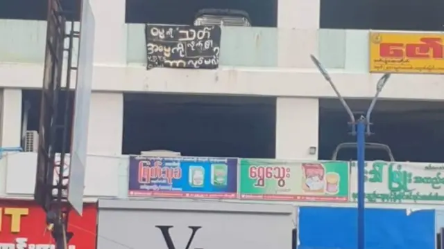 ဇူလိုင် ၂၅ရက်၊ ရန်ကုန်မြို့၊ ယုဇနပလာဇာမှာ စာတန်းချိတ်ဆွဲဆန္ဒထုတ်ဖော်ထားတဲ့မြင်ကွင်းဖြစ်ပါတယ်။