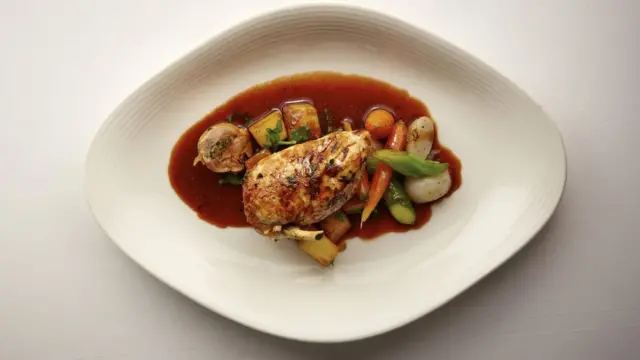 Курица на тарелке с соусом.