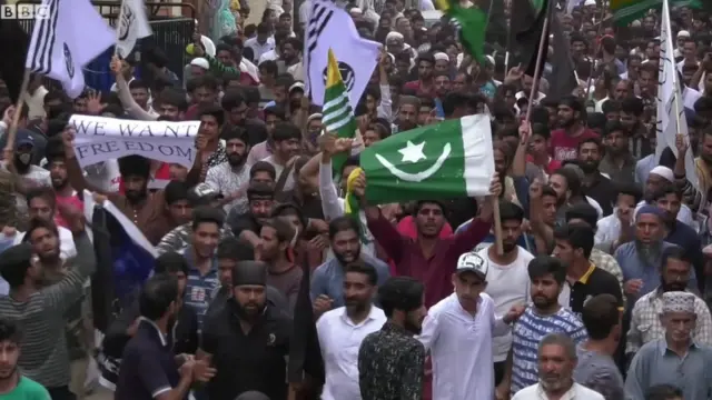 শুক্রবারের বিক্ষোভে কিছু বিক্ষোভকারীর হাতে দেখা যায় চাঁদাতারা-খচিত পতাকা