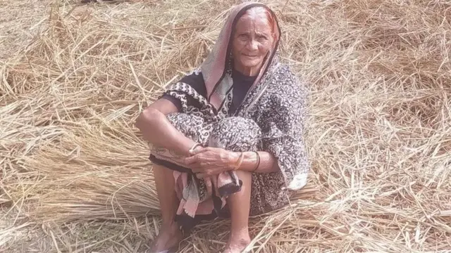 দ পোহাচ্ছেন একজন প্রবীণ গ্রামীণ নারী