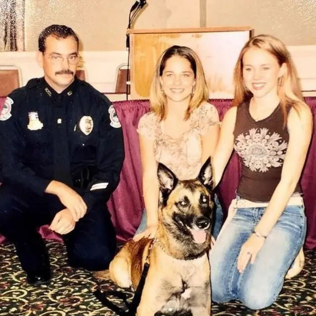 Kara com policial, pastor alemão e outra mulher