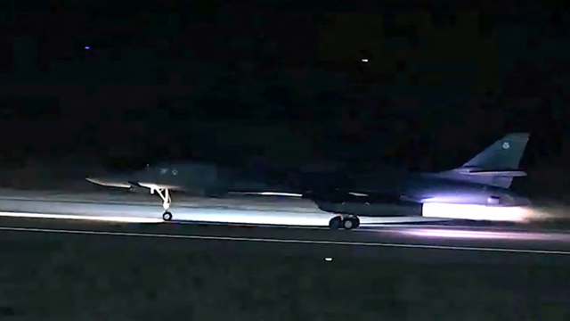 一架B-1轰炸机在黑暗中从跑道起飞。