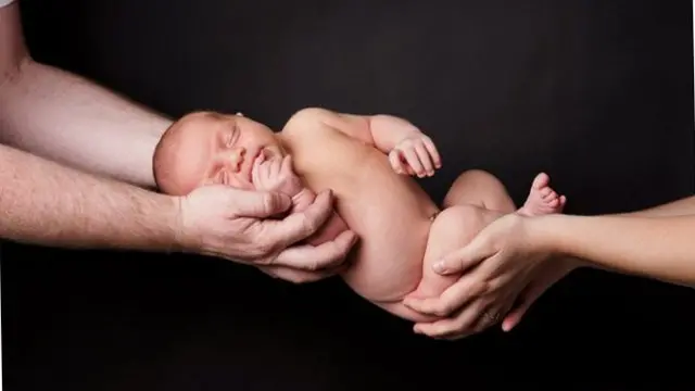 Baby being handed over