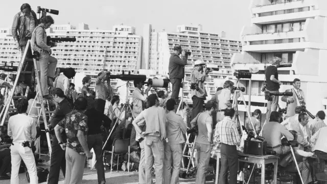 ओलंपिक विलेज के बाहर खड़े फोटोग्राफ़र