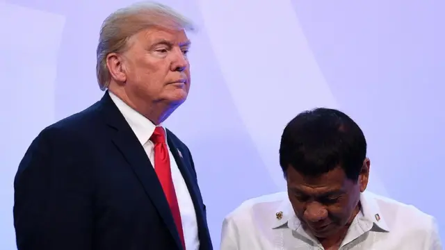 US President Donald Trump (L) walks past Philippine President Rodrigo Duterte after posing for a family photo during the ASEAN-US 40th Anniversary commemorative Summit on the sideline of the 31st Association of Southeast Asian Nations (ASEAN) Summit in Manila on November 13, 2017.