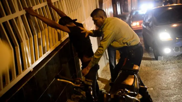 Un policía requisa a un joven