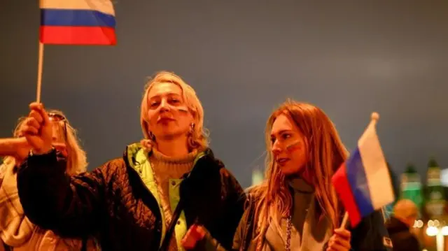 De jeunes femmes tenant le drapeau russe.