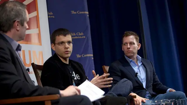 Max Levchin e Peter Thiel sentados, em uma conferência de negócios