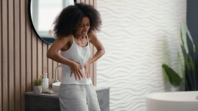 Black woman get stomach pain as she stand for bathroom 