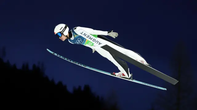 Китайский прыгун с трамплина Сун Циву летит в воздухе