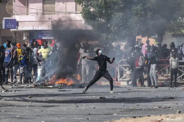 Un jeune manifestant sénégalais lançant des pierres aux forces de l'orde