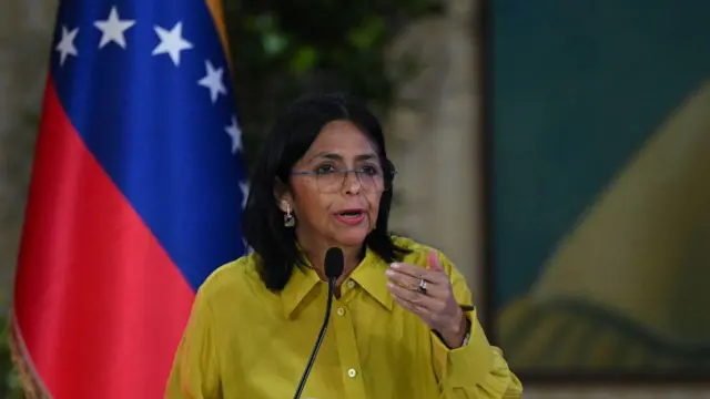 Delcy Rodríguez, com a bandeira da Venezuela ao fundo