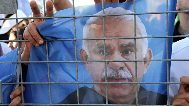 28 Haziran'da Diyarbakır'daki Özgürlük Mitingi'nde bir kişi PKK lideri Abdullah Öcalan'ın posterini elinde tutuyor ve zafer işareti yapıyor.