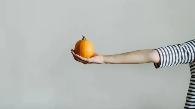 Жіноча рука тримає гарбузик