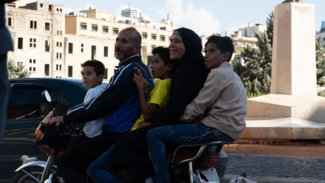 Família de cinco pessoas em motocicleta.