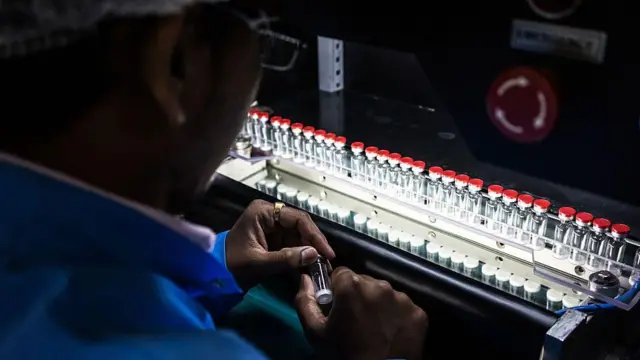 یک کارخانه تولید واکسین در هند. یک کارمند و شمار زیادی از بوتل‌های واکسین دیده می‌شود