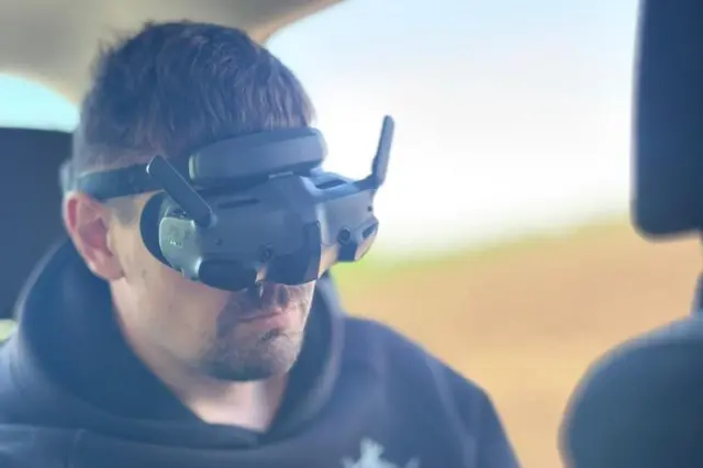 Хлопець в машині сидить в VR-окулярах