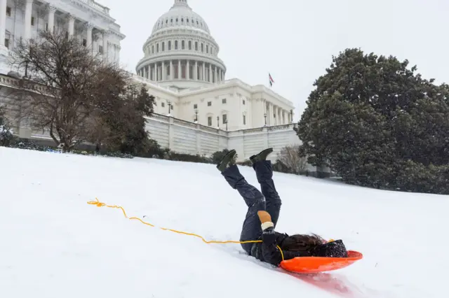 дете се санка на нараџастим санкама испред Капитола у Вашингтону