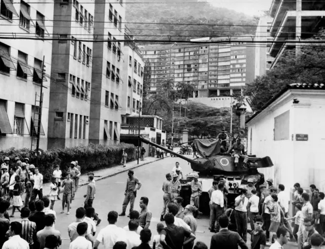 Una fotografía en blanco y negro del momento del golpe de Estado de 1964. En la imagen, tomada en Río de Janeiro, se ve a ciudadanos alrededor de un tanque.