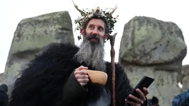 شخص يحتفل بالانقلاب الشتوي في ستوهينج في انجلترا احتفالا بأطول ليلة في العام في النصف الشمالي للكرة الأرضية