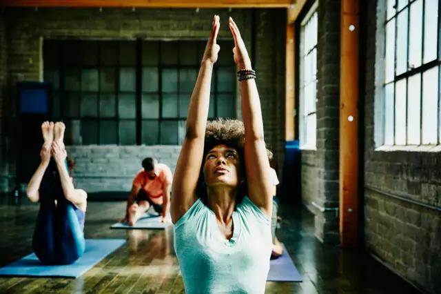 Un grupo de hombres y mujeres practicando yoga