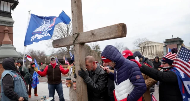 कैपिटल हिल के बाहर ट्रंप समर्थक क्रॉस के साथ नज़र आए थे.