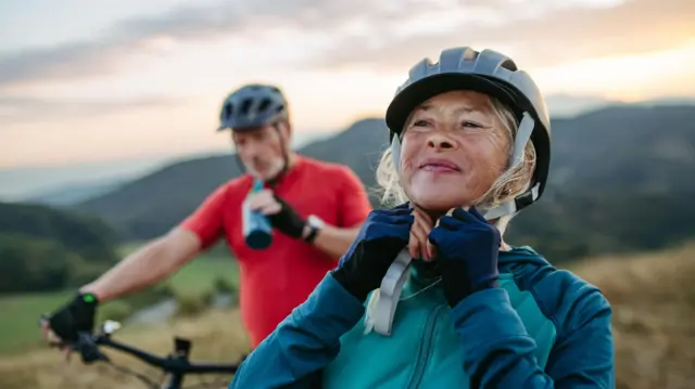 Pasangan lansia bersepeda di alam terbuka
