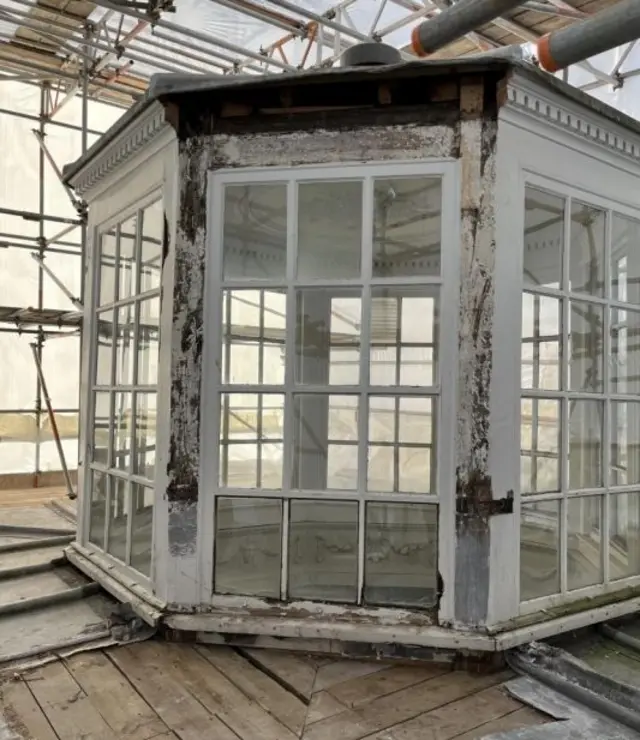 Una claraboya octogonal tipo "linterna", rodeada de andamios. Cada uno de los ocho lados tiene una ventana de 12 paneles con marcos blancos.