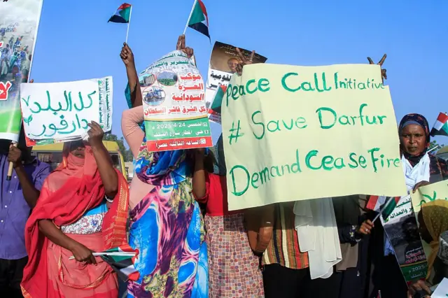 Des personnes brandissent des drapeaux nationaux et des pancartes lors d'un rassemblement organisé par le Front populaire pour la libération et la justice à Port-Soudan, le 24 avril 2025.