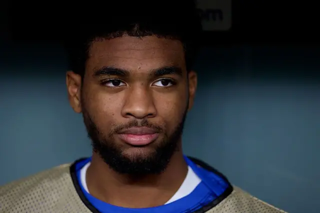 Ibrahim Mbaye filmé des épaules à la tête, porte un dessous blanc avec un t-shirt bleu et un chasuble de couleur kaki. Il ne regarde pas dans l'objectif de la caméra.