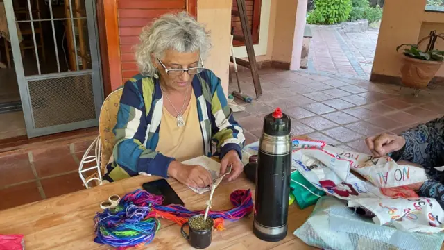 Mujer bordando sobre una mesa