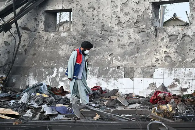 یو سړی د روږدو کسانو درملنې مرکز په بمبار شوې ودانۍ کې ګرځي.