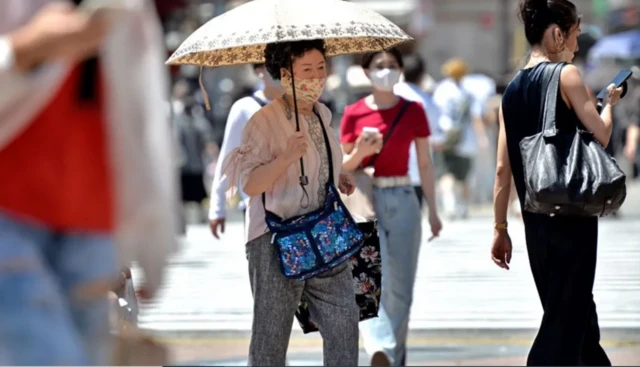 2022년 6월 일본 도쿄의 시부야 거리에서 한 노인이 양산을 쓰고 걷고 있다