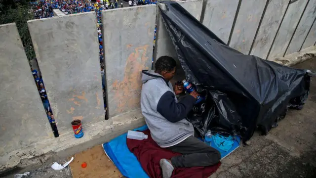 Um morador de rua senta-se em sua barraca improvisada em São Paulo, em 30 de maio de 2024.