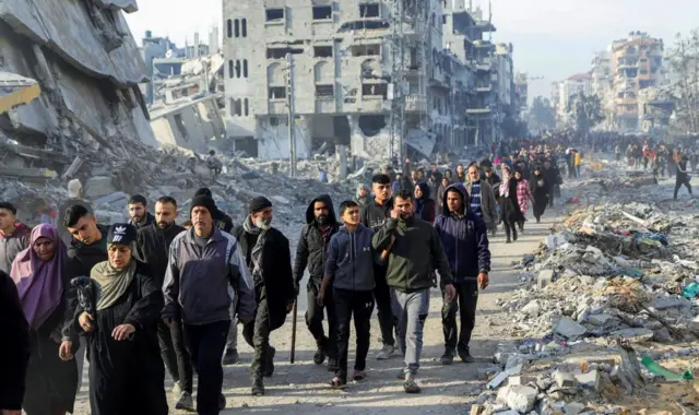 Pazar günü ilan edilen ateşkes ile binlerce Filistinli yeniden yollara düştü, yıkıntılar arasında ilerleyen binlerce Filistinlinin perspektif şekilde fotoğrafı