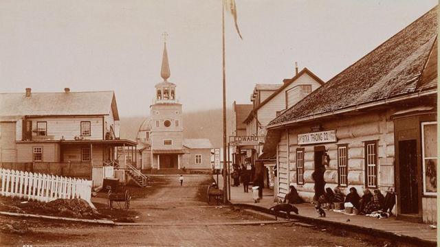 Varias mujeres nativas americanas sentadas en la calle frente a la Sitka Trading Company en Sitka, Alaska. Sitka fue la sede de la Compañía Ruso-Americana y durante el siglo XIX fue el lugar de un próspero comercio de pieles, lo que le valió el sobrenombre de 