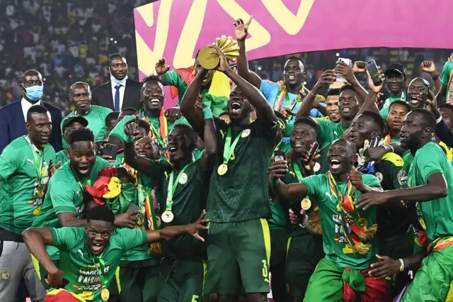 Les joueurs sénégalais célèbrent avec le trophée après avoir remporté la finale de la Coupe d'Afrique des Nations (CAN) 2021 devant l'Egypte au Stade d'Olembe à Yaoundé, le 6 février 2022.