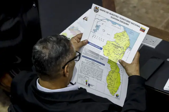 Un diputado venezolano viendo el mapa de Venezuela con el Esequibo incluido.