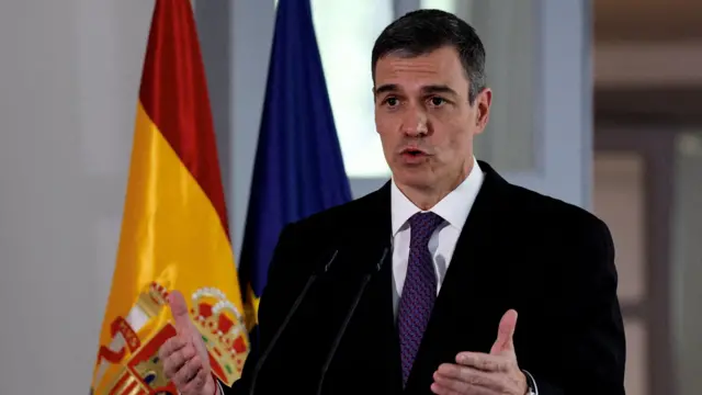 O primeiro-ministro espanhol, Pedro Sánchez, fala em frente à bandeira da Espanha