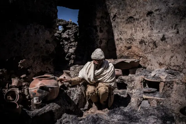 Fekede Amare, 41, shows his burned down house, allegedly attacked by Tigray forces in Mesobit, Ethiopia, on December 06, 2021.