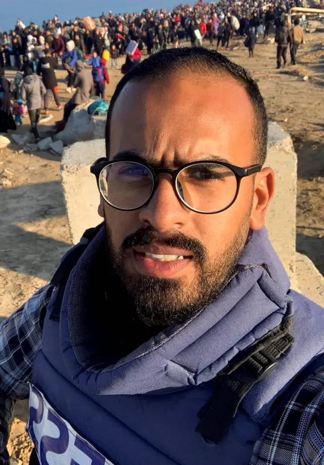 الصحفي أحمد أبو عزيز بصورة سلفي يرتدي سترة الصحفيين