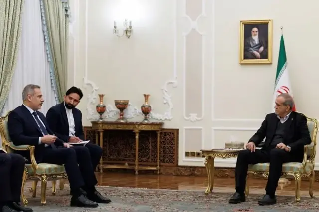 دیدار هاکان فیدان با مسعود پزشکیان، یک مترجم بین آنها نشسته است