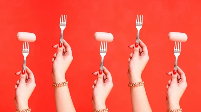 Des mains alignées sur fond rouge et tenant des fourchettes.
