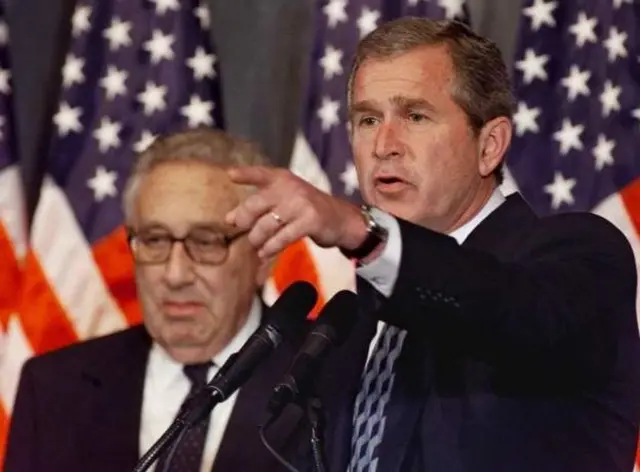 George W Bush (iburyo) atunze urutoki ari kumwe na Henry Kissinger
