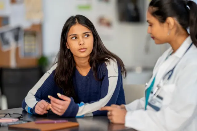 Female doctor consults with a young woman patient in a clinic