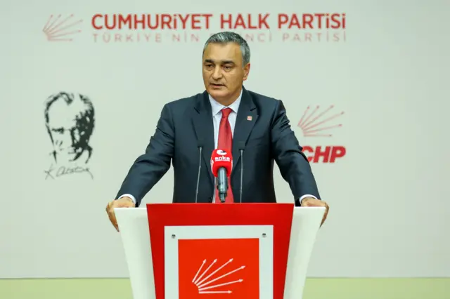 Bir adam CHP logolu kürsüde konuşuyor
