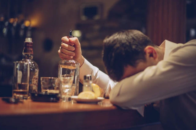 รูปผู้ชายเมาฟุบกับโต๊ะ 